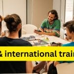 Photo of people at a Stay Grounded conference sitting around a table chatting and laughing.